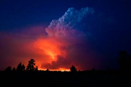 En esta fotografía proporcionada por los bomberos del estado de Oregon, llamas y humo se elevan el miércoles 14 de julio de 2021 desde un incendio en el sur de Oregon. (John Hendricks/Oficina de los bomberos del estado de Oregon vía AP)