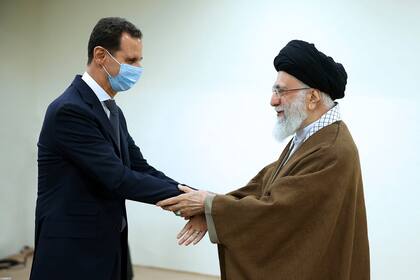 En esta fotografía publicada por el sitio web oficial de la oficina del líder supremo iraní, el ayatolá Alí Jamenei (derecha) estrecha la mano del presidente sirio Bashar Assad, en Teherán, Irán, el domingo 8 de mayo de 2022. (Oficina líder supremo iraní vía AP)