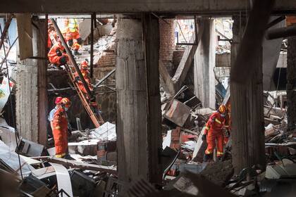 En esta fotografía publicada por la agencia noticiosa Xinhua, rescatistas buscan sobrevivientes el domingo 13 de junio de 2021 entre los escombros provocados por una explosión de gas en la ciudad de Shiyan, en la provincia central de Hubei, China. (Xiao Yijiu/Xinhua vía AP)