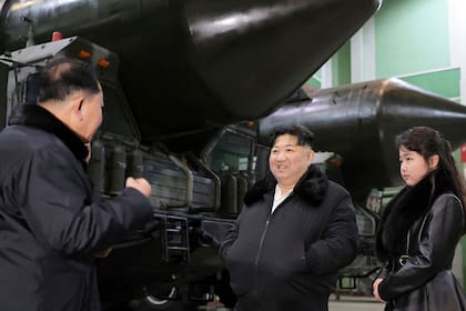 En esta fotografía sin fecha proporcionada por el gobierno de Corea del Norte el viernes 5 de enero de 2024, el gobernante norcoreano Kim Jong Un visita con su hija una fábrica que produce transportadores erectores lanzadores en el país