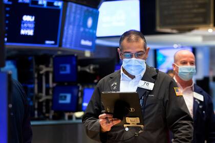 En esta imagen cortesía de la Bolsa de Valores de Nueva York se ve al operador Aman Patel en el piso de operaciones, el martes 18 de enero de 2022, en Nueva York. (Allie Joseph/New York Stock Exchange via AP)