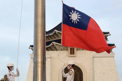 En esta imagen de archivo, dos soldados arrían la bandera nacional de Taiwán durante una ceremonia diaria en la Plaza de la Libertad, en el memorial Chiang Kai-shek, en Taipéi, Taiwán, el 30 de julio de 2022. (AP Foto/Chiang Ying-ying, archivo)