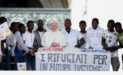 En esta imagen de archivo, el papa Francisco posa para una fotografía con un grupo de refugiados a los que invitó a las escaleras de la Basílica de San Pedro, con una bandera con la frase (en italiano) "Los refugiados para un futuro junto"