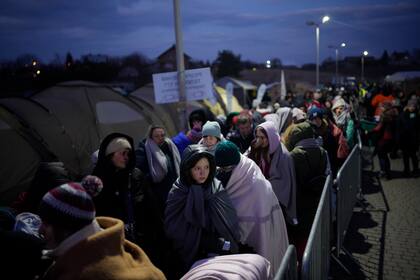 En esta imagen de archivo, refugiados que huyen de la vecina Ucrania esperan en el paso fronterizo de Medyka, en Polonia, el 10 de marzo de 2022. Unos 2,5 millones de personas han escapado de Ucrania desde el inicio de la invasión rusa hace dos semanas. La mayoría de ellos ha llegado a la Unión Europea. (AP Foto/Daniel Cole, archivo)