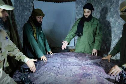 En esta imagen de archivo sin fecha, distribuida por un grupo insurgente en 2016, se muestra a Abu Mohammed al-Golani, el líder de la filial de Al Qaeda en Siria (segundo por la derecha), discutiendo detalles del campo de batalla con comandantes en Alepo, Siria. (Imagen de grupo insurgente vía AP, archivo)