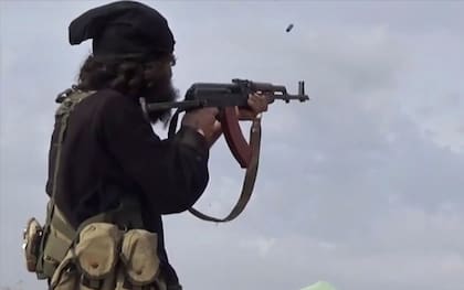 En esta imagen de archivo, tomada de un video publicado en internet el 18 de marzo de 2019 por la agencia noticiosa Aamaq, el brazo mediático del grupo extremista Estado Islámico, muestra a un combatiente de ISIS disparando su arma durante choques con combatientes de las Fuerzas Democráticas Sirias, respaldadas por EEUU, en Baghouz, Siria. (Agencia noticiosa Aamaq vía AP, archivo)