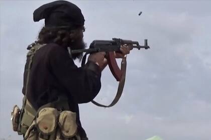 En esta imagen de archivo, tomada de un video publicado en internet el 18 de marzo de 2019 por la agencia noticiosa Aamaq, el brazo mediático del grupo extremista Estado Islámico, muestra a un combatiente de ISIS disparando su arma durante choques con combatientes de las Fuerzas Democráticas Sirias, respaldadas por EEUU, en Baghouz, Siria. (Agencia noticiosa Aamaq vía AP, archivo)