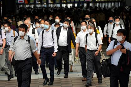 En esta imagen de archivo, tomada el 12 de julio de 2021, pasajeros, con mascarilla para protegerse del coronavirus, caminan por un pasillo en plena hora punta, en la estación de Shinagawa, en Tokio. (AP Foto/Eugene Hoshiko, archivo)