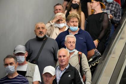 En esta imagen de archivo, tomada el 29 de junio de 2021, un grupo de personas baja en escalera mecánica hacia el metro en plena pandemia del coronavirus, en San Petersburgo, Rusia. (AP Foto/Dmitri Lovetsky, archivo)