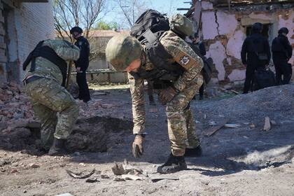 En esta imagen de archivo, un agente de policía examina fragmentos de una bomba guiada tras un ataque aéreo ruso sobre Jarkív, Ucrania, el 30 de abril de 2024. (AP Foto/Andrii Marienko, archivo)