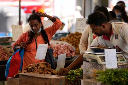 En esta imagen de archivo, una mujer regatea mientras compra verduras en un mercado en Colombo, Sri Lanka, el 10 de junio de 2022. (AP Foto/Eranga Jayawardena, archivo)