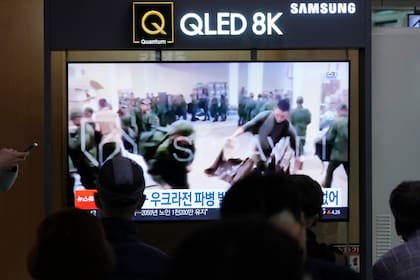 En esta imagen de archivo, una pantalla de televisión muestra imágenes de presuntos soldados norcoreanos en fila para recibir suministros de Rusia. (AP/Ahn Young-joon, archivo)