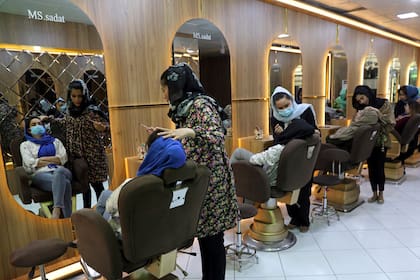En esta imagen de archivo, varias empleadas maquillan a clientas en el salón de belleza Ms. Sadat, en Kabul, Afganistán, el 25 de abril de 2021