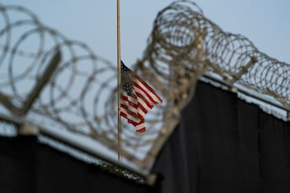 En esta imagen del 29 de agosto de 2021 revisada por oficiales militares de Estados Unidos, una bandera ondea a media asta en una vista desde Camp Justice, en la Base Naval de Bahía de Guantánamo, Cuba