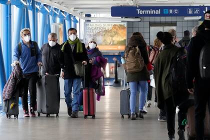 En esta imagen del 30 de diciembre de 2021 se puede ver a viajantes mientras caminan por la terminal 1 del Aeropuerto Internacional O'Hare, en Chicago. (AP Foto/Nam Y. Huh, Archivo)