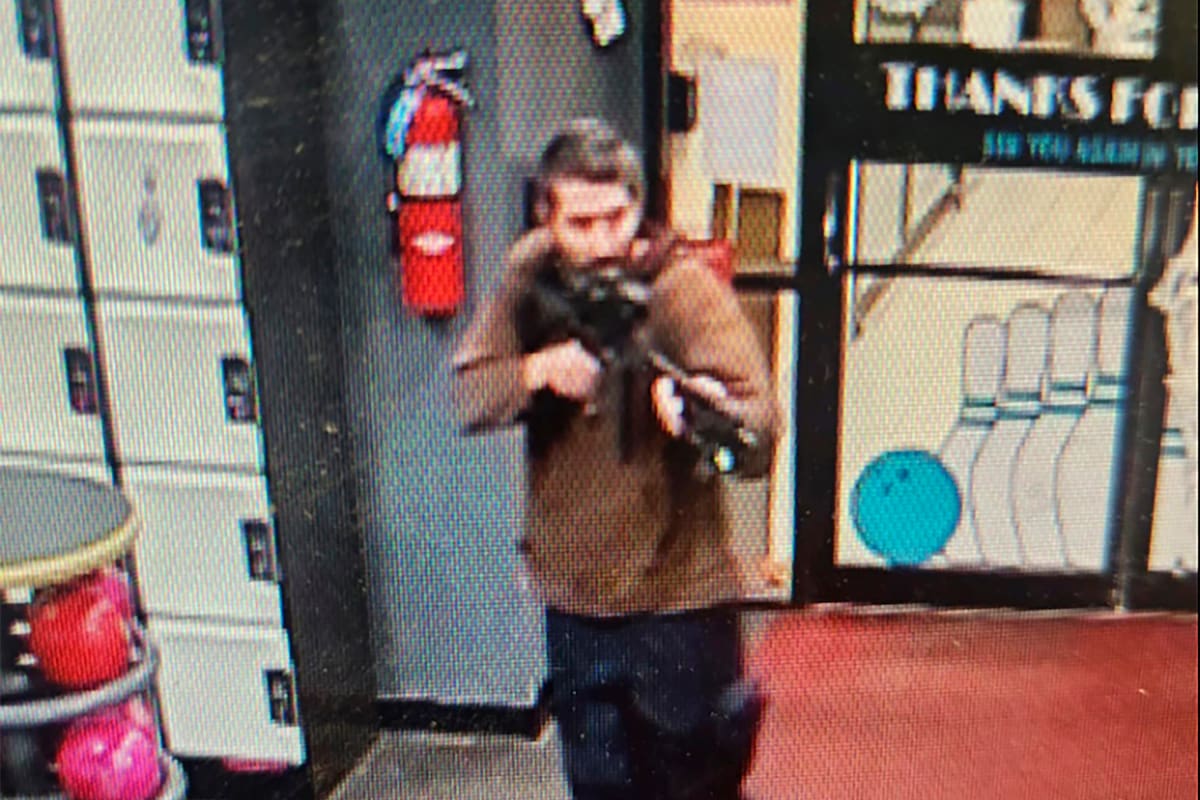 En esta imagen difundida por el Departamento de Policía del condado Androscoggin se ve a un hombre armado no identificado que apunta su fusil mientras ingresa al local Sparetime Recreation, el miércoles 25 de octubre de 2023, en Lewiston, Maine.