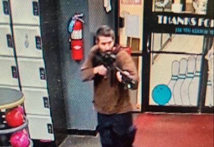 En esta imagen difundida por el Departamento de Policía del condado Androscoggin se ve a un hombre armado no identificado que apunta su fusil mientras ingresa al local Sparetime Recreation, el miércoles 25 de octubre de 2023, en Lewiston, Maine. (Departamento de Policía del condado Androscoggin via AP)