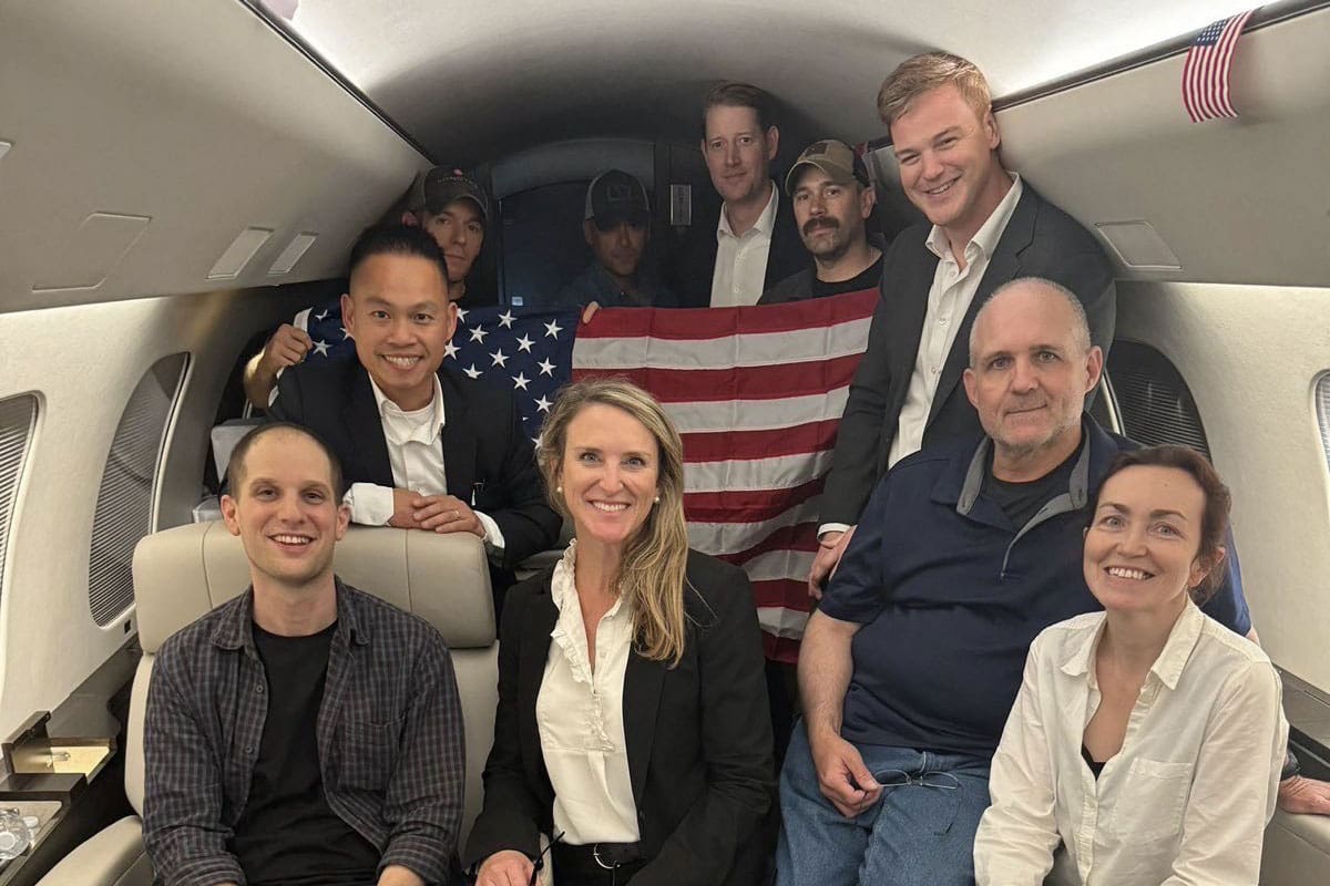 En esta imagen difundida por el gobierno de Estados Unidos, el periodista estadounidense Evan Gershkovich (izq.), el exmarine estadounidense Paul Whelan (2do. der.) y la periodista ruso-estadounidense Alsu Kurmasheva (der.) aparecen en un avión tras su liberación de Rusia el 1 de agosto de 2024.
