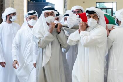 En esta imagen, distribuida por el Ministerio de Presidencia, el jeque Mohamed bin Zayed Al Nahyan, que gobierna Abu Dabi (delante izquierda), y el jeque Mansour bin Zayed Al Nahyan, viceprimer ministro y ministro de la Presidencia de Emiratos (delante derecha), trasladan el cuerpo del jeque Khalifa bin Zayed Al Nahyan, presidente de Emiratos, junto a otros miembros de la familia real, en la mezquita Jeque Sultán bin Zayed Primero, en Abu Dabi, el 13 de mayo de 2022. (Hamad Al Kaabi/Ministerio de Presidencia vía AP)