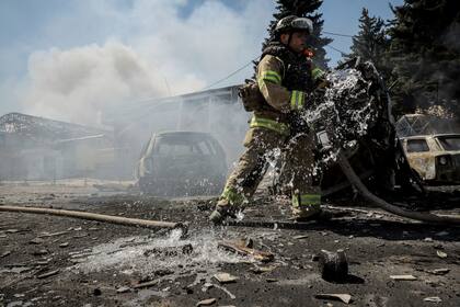 En esta imagen, distribuida por el servicio de prensa de la 24ta Brigada Mecanizada de Ucrania, un bombero sofoca un incendio provocado por un dron ruso en un mercado en la localidad de Druzhkivka, en la región de Donetsk, Ucrania, el 2 de agosto de 2025.