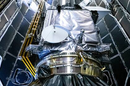 En esta imagen distribuida por la NASA, técnicos de NASA y SpaceX colocan la sonda PACE de la NASA en el carenado de carga útil del cohete Falcon 9 de SpaceX, el 30 de enero de 2024, en el Centro de Operaciones Espaciales Astrotech, cerca del Centro Espacial Kennedy de la agencia en Florida, (NASA vía AP)