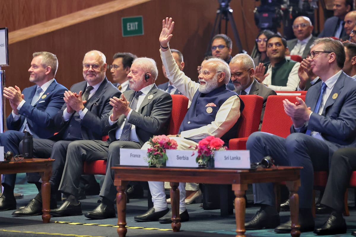 En esta imagen, distribuida por la oficinal del primer ministro de India, Narendra Modi (centro), alza para mano para saludar mientras otros mandatarios internacionales aplauden durante una cumbre sobre inteligencia artificial en Nueva Delhi, India, el 19 de febrero de 2026. (Oficina del primer ministro de India vía AP)
