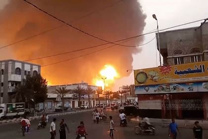 En esta imagen extraída de un video, humo y llamas se alzan desde un lugar en Hodeida, Yemen (AP Foto)