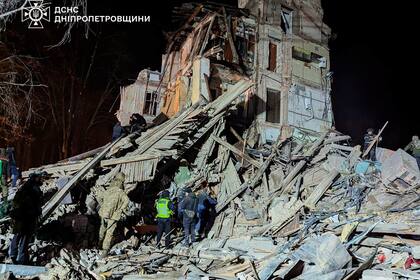En esta imagen facilitada por el Servicio de Emergencias de Ucrania el miércoles 25 de diciembre de 2024, los bomberos trabajan en el solar de un edificio de apartamentos destruido por un ataque ruso en Kryvyi Rih, Ucrania. (Ukrainian Emergency Service via AP)