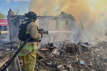 En esta imagen proporcionada por el Servicio de Emergencias de Ucrania, un bombero combate un incendio en viviendas en ruinas tras un ataque ruso en la región de Donetsk, Ucrania, el lunes 28 de abril de 2025. (Servicio de Emergencias de Ucrania vía AP)