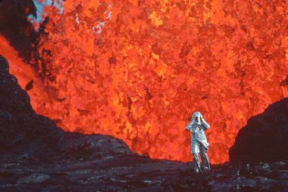 En esta imagen proporcionada por National Geographic Katia Krafft con un traje térmico junto a la lava del volcán Krafla en una escena del documental "Fire of Love". (National Geographic vía AP)
