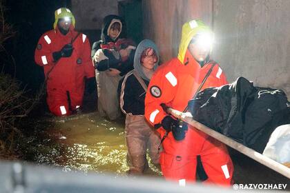 En esta imagen publicada por el canal de Telegram del gobernador de Sebastopol, Mikhail Razvozhayev, rescatistas evacúan a gente tras una tormenta que causó inundaciones en Sebastopol, Crimea, el lunes 27 de noviembre de 2023. (Canal de Telegram del gobernador de Sebastopol, Mikhail Razvozhayev, via AP)