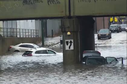 En esta imagen tomada de un video cortesía de ABC7 Chicago, varios vehículos yacen atrapados en una inundación en las avenidas Fifth y Cicero, el domingo 2 de julio de 2023, en Chicago. (ABC7 Chicago via AP)