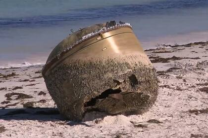En esta imagen tomada de un video, vista de un objeto cilíndrico en una playa en Green Head, Australia, el 17 de julio de 2023. (CHANNEL 9 vía AP)