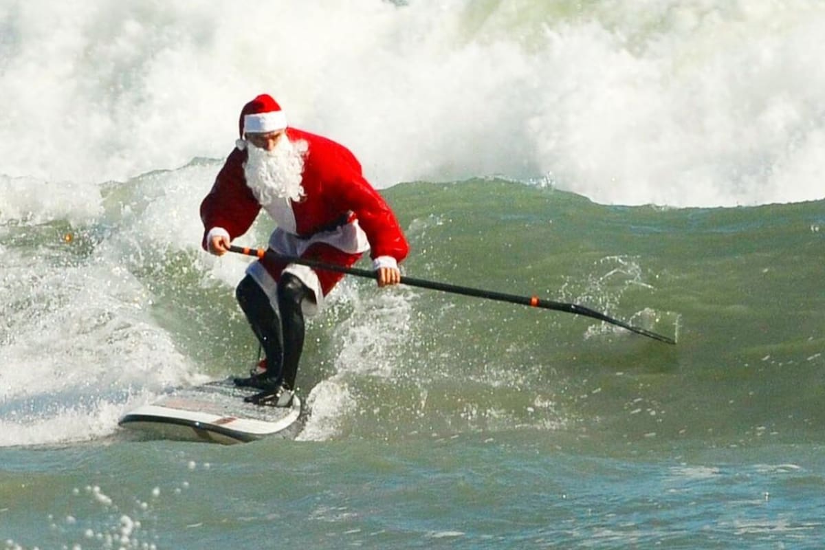 En esta playa de Orlando Papá Noel aparece sobre una tabla de surf en uno de los eventos más esperados de Navidad (Instagram/@surfingsantas)