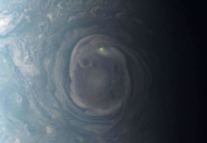 En esta vista de un vórtice cerca del polo norte de Júpiter, la misión Juno de la NASA observó el resplandor de un rayo.