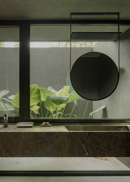 En este toilette, se colocó un gran espejo suspendido que suma carácter y armonía al ambiente. La mesada se resolvió con una bacha armada de Dekton.