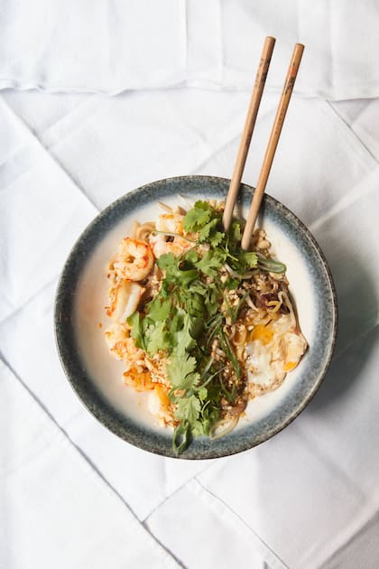 En Estrecho: Pad Thai de langostinos que lleva pasta de arroz, puerros, brotes de soja, salsa de tamarindo picante, cilantro, maní y huevo.