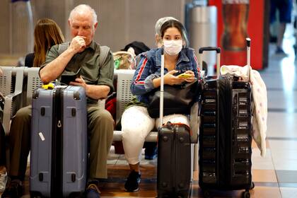 En Ezeiza, ayer, algunos pasajeros usaban barbijos mientras esperaban para embarcar