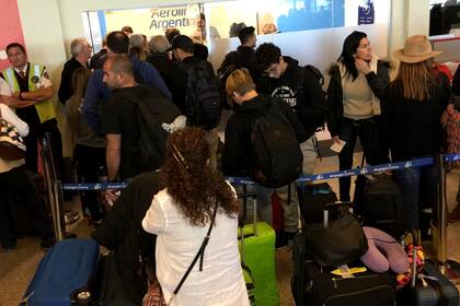 En Ezeiza, los pasajeros se agolpan frente a la oficina de ventas de Aerolíneas Argentinas para conocer cuándo podrán volar