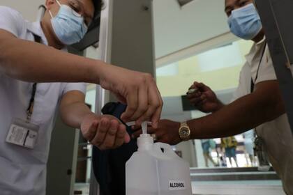 En Filipinas, estudiantes se higienizan con alcohol en gel para prevenir el contagio del coronavirus que mató a una persona en el país, la primera víctima fatal del virus fuera de China