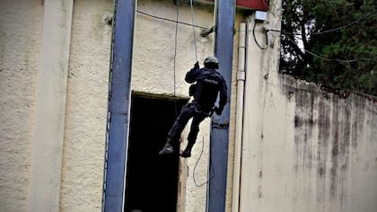 En forma simultánea un grupo ingresa por la puerta y por las ventanas de la vivienda, al tiempo que se arrojan cargas explosivas inertes para aturdir a los ocupantes