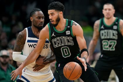 En foto del domingo 27 de marzo del 2022, Jayson Tatum de los Celtics de Boston busca superar al base de los Timberwolves de Minnesota Jaylen Nowell en Boston. (AP Foto/Steven Senne)