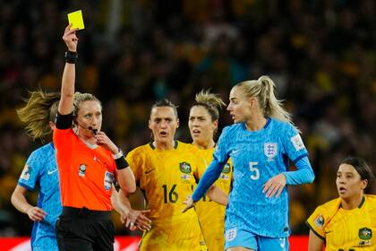 En foto del miércoles 16 de agosto del 2023, la árbitra Tori Penso le muestra una tarjeta amarilla a Alex Greenwood de Inglaterra durante la semifinal de la Copa Mundial femenina ante Australia. El viernes 18 de agosto del 2023, FIFA elige a Penso para pitar la final del domingo. (AP Foto/Abbie Parr)