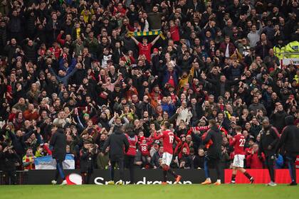 En foto del sábado 14 de enero del 2023, jugadores del Manchester United saludan a los aficionados en el encuentro ante el Manchester City en la Liga Premier. El martes 17 de enero del 2023, el multimillonario Jim Radcliffe presenta una puja para comprar al United. (AP Foto/Dave Thompson)