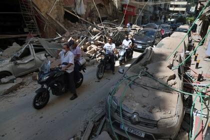 Autos destruidos y edificios arrasados, una realidad que demorará meses en disiparse en medio de una severa crisis económica y de la pandemia de coronavirus