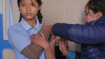 En Katmandú, Nepal, una estudiante nepalí recibe una dosis de la vacuna contra el virus del papiloma humano (VPH) en una escuela local