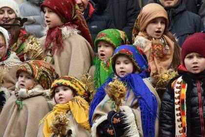 En la ciudad occidental de Lviv, que ha sufrido pocos daños por la guerra, niños vestidos con trajes tradicionales cantaron villancicos y participaron en procesiones festivas en las calles.