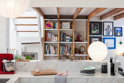 En la cocina abierta, se eligieron mesadas de mármol de carrara. La biblioteca es un diseño de la arquitecta.