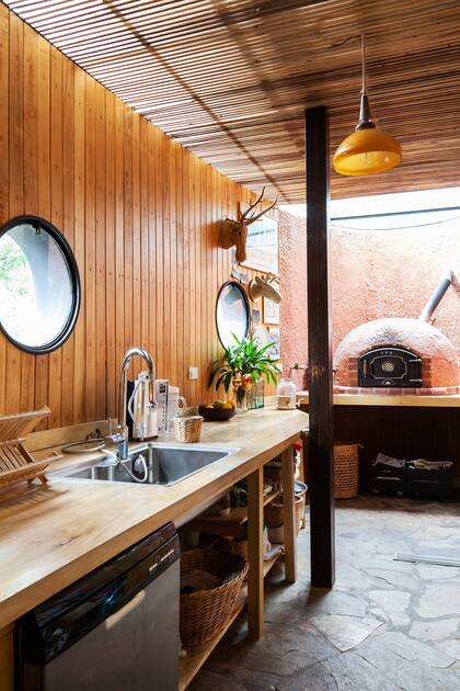 En la cocina, la mesada es de guatambú; el revestimiento, de kiri y las varillas del techo, de laurel. El horno de barro y la pared que lo sostiene están revestidos de sobrantes de azulejos de otros espacios de la casa