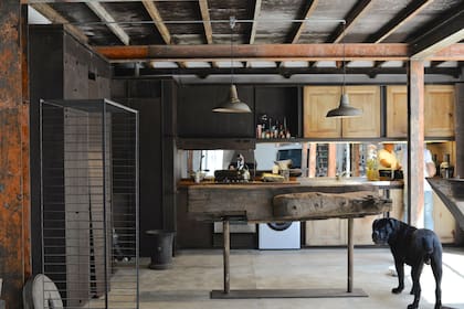 La cocina se construyó con vigas de hierro, madera y descartes de obra. Una pieza de madera de una antigua barcaza del puerto de Maldonado reemplaza la clásica barra en el desayunador.